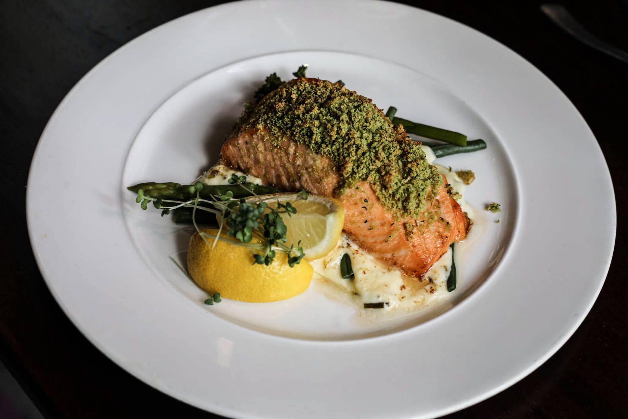 Herb-crusted salmon on creamed potato with lemon